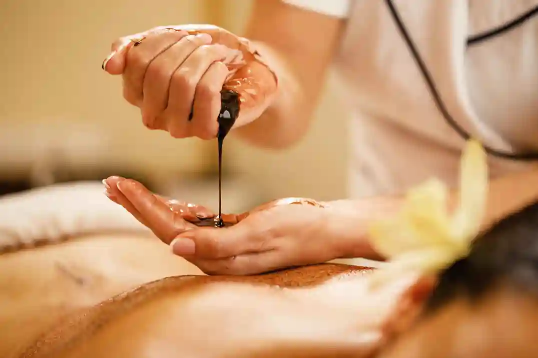closeup-massage-therapist-pouring-hot-chocolate-her-hands-before-spa-treatment_11zon